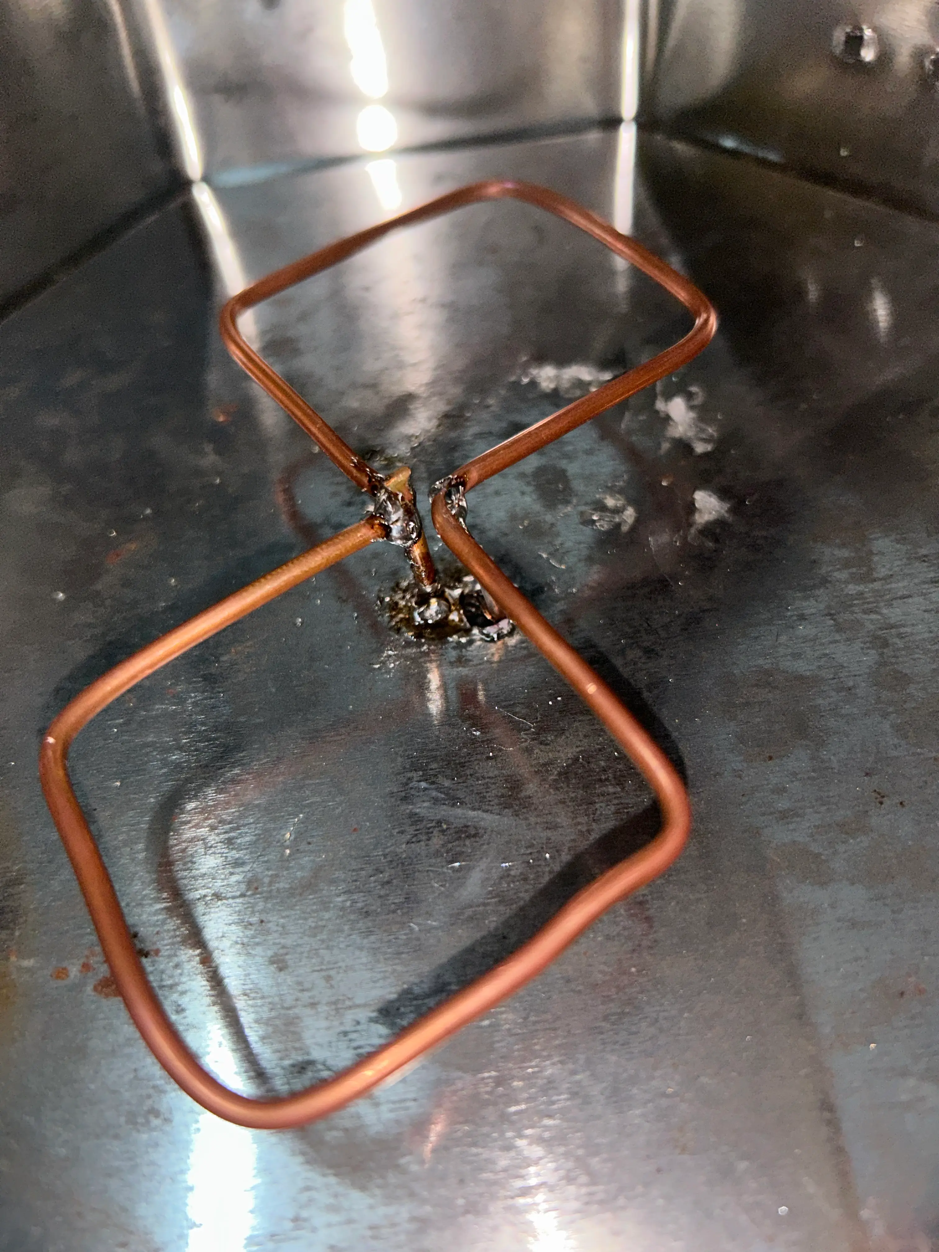 Biquad antenna soldering inside the biscuit tin box i used as a reflector plate